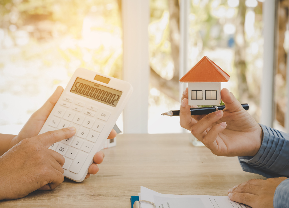 calculatrice et maison miniature pour symboliser la taxe sur la plus-value immobilière